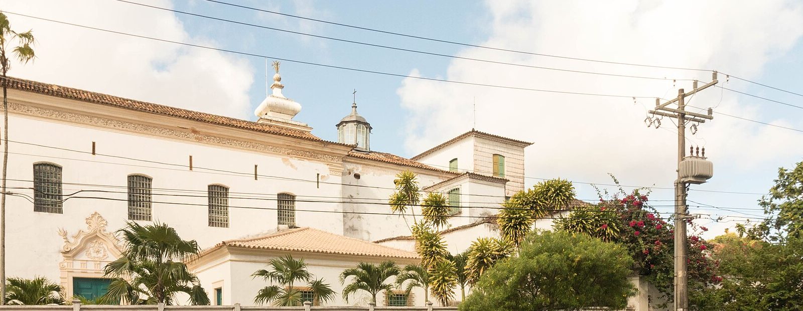 Fachada branca da Igreja e Convento do Desterro, com palmeiras e o portal barroco